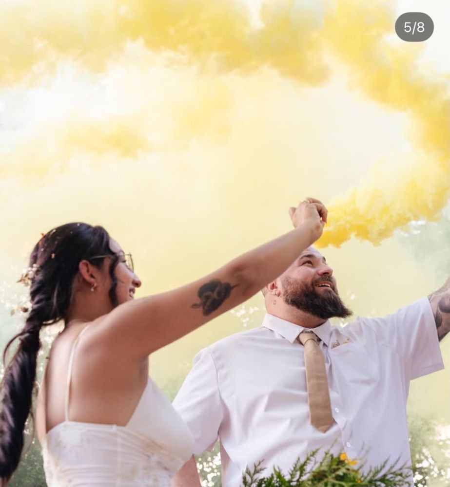Pareja celebrando con humo amarillo en la ceremonia